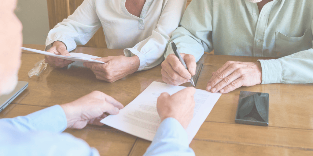 A couple reviewing and signing funeral planning documents with an advisor